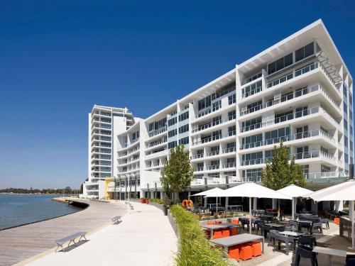 a hotel room with a balcony overlooking the ocean at The Sebel Mandurah in Mandurah