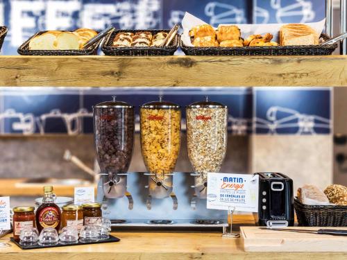 a shelf with three glasses filled with food and bread at ibis Budget Colmar Centre Gare in Colmar