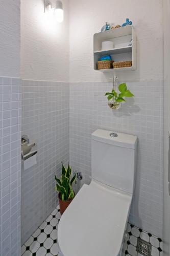 a bathroom with a white toilet and blue tiles at Civil Life Tainan in Tainan
