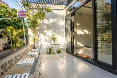 a patio with two chairs and a table and windows at D Central Hoi An Homestay in Hoi An