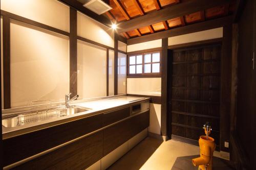ein großes Bad mit einem Waschbecken und einem Fenster in der Unterkunft 紀州湯浅古民家町屋宿泊 千山庵 SenzanAn かじやまち301 in Yuasa