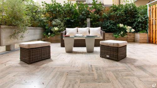 a patio with a table and two wicker chairs at Verdeluna ApartHotel in Marina di Pietrasanta