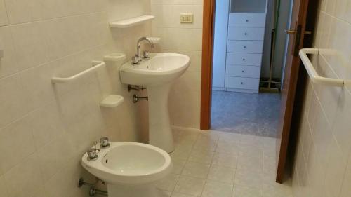 a white bathroom with a sink and a toilet at Residence Azzurro in Massignano