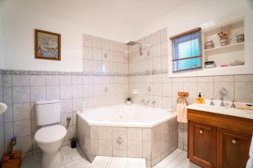 a bathroom with a tub and a toilet and a sink at Ruby's Cottage in Penola