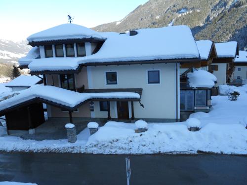 a house with snow on the roof at Ferienwohnung Maierhofer in Krimml