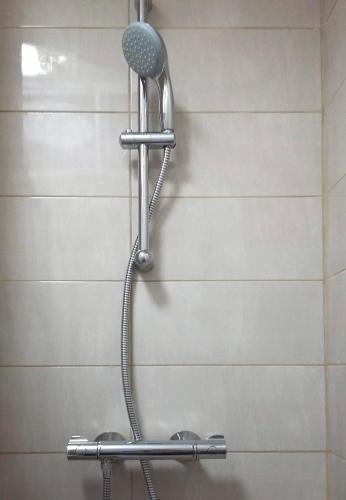 a shower with a shower head in a bathroom at Horizon Apartment in Varna City
