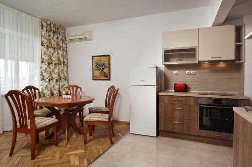 eine Küche mit einem Tisch und einem weißen Kühlschrank in der Unterkunft Horizon Apartment in Warna