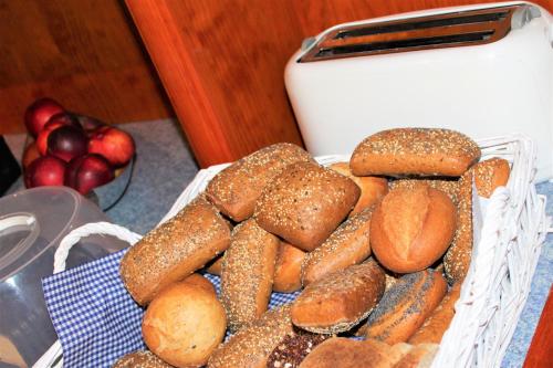 a basket full of bagels and apples next to a toaster at Hotel Alsterquelle in Henstedt-Ulzburg