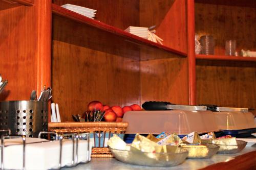 a kitchen with a counter with bowls of food at Hotel Alsterquelle in Henstedt-Ulzburg