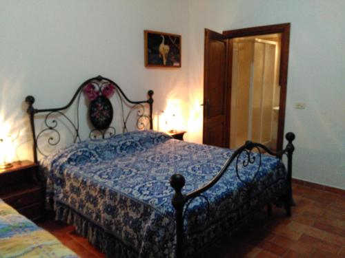 a bedroom with a bed with a blue comforter at Agriturismo Uliveto Gretacci in Montemerano