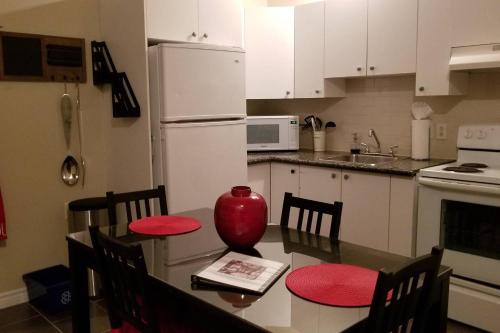 a kitchen with a table with a red vase on it at Sweet 2-Bedroom Penthouse Apartment by Amazing Property Rentals in Gatineau