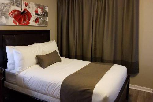 1 dormitorio con 1 cama con sábanas blancas y ventana en Sweet 2-Bedroom Penthouse Apartment by Amazing Property Rentals, en Gatineau