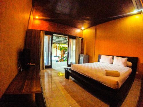 a bedroom with a bed and a large window at Leyeh Leyeh Homestay in Canggu