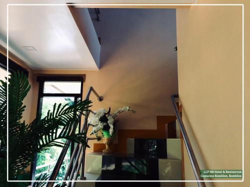 a staircase with a vase of flowers on a table at LCF - BB Hotel in Romblon