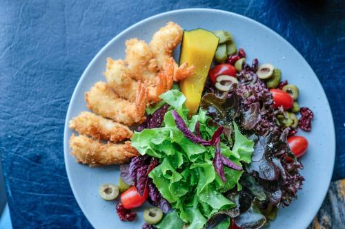 a plate of food with a salad and vegetables at Inlaya Ratchaburi in Ratchaburi