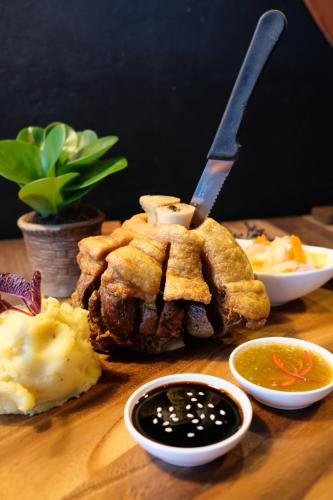 a table with a plate of food with a knife at Inlaya Ratchaburi in Ratchaburi