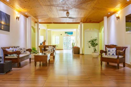 a large living room with couches and chairs at Captain's Villa in Takamaka
