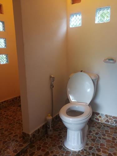 a bathroom with a white toilet in a room at Lazy Bones in Koh Rong Sanloem