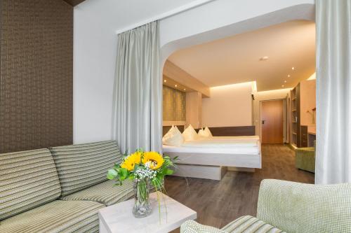 a hotel room with a couch and a bed at Bliem's Familienhotel in Haus im Ennstal
