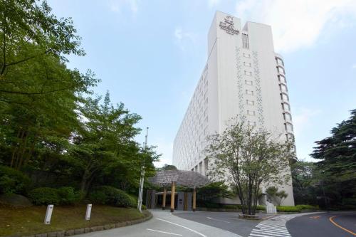 a tall white building with a street in front of it at The Prince Sakura Tower Tokyo, Autograph Collection in Tokyo