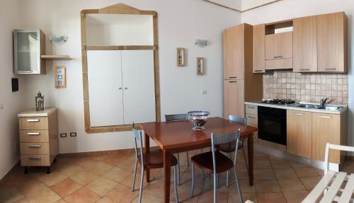 una cucina con tavolo, sedie e specchio di Il Corbezzolo a Santa Cesarea Terme