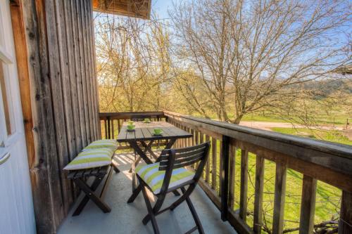 a table and chairs on a balcony with a view at Zeitraumferien in Bernau am Chiemsee