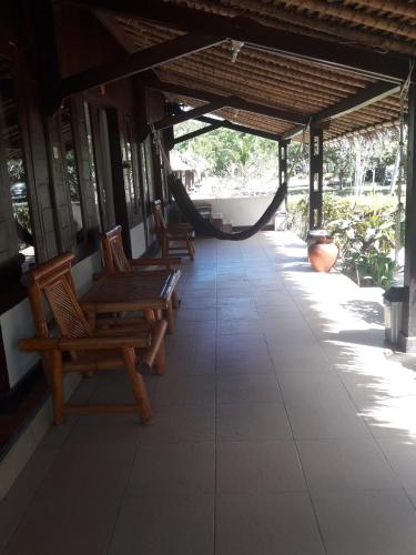 a porch with benches and a hammock in a building at Selong Belanak Bungalows in Selong Belanak