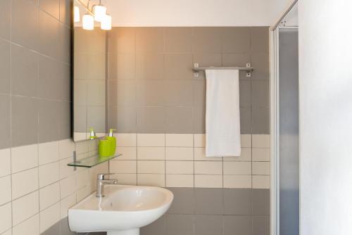 łazienka z umywalką i lustrem w obiekcie Aura Marina Apartments Santorini w Akrotiri