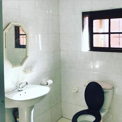 a bathroom with a sink and a toilet and a mirror at Hill Top Farm Lodge in Sea Park