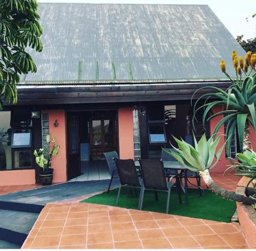 una casa con sillas y una mesa frente a ella en Hill Top Farm Lodge, en Sea Park