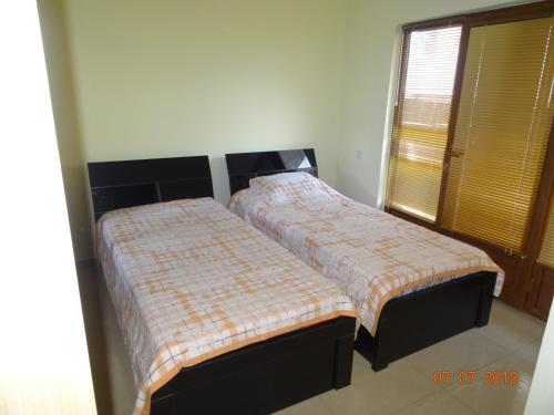 two beds sitting next to each other in a bedroom at LN'S APARTMENT in Borjomi