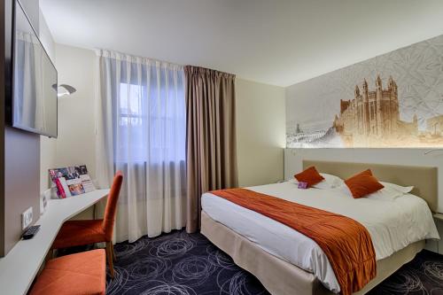 a hotel room with a bed and a desk at Mercure Albi Rives du Tarn in Albi