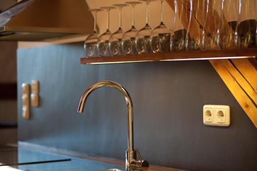 a kitchen sink with a faucet and glasses on a shelf at Zeitraumferien in Bernau am Chiemsee