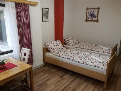 a small room with a bed and a table at Apartments Emir in Tuzla