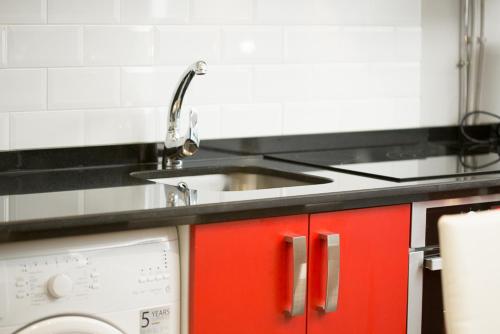 a kitchen with a sink and a washing machine at Apartamentos Dacris in Jerte
