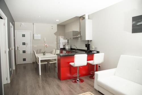 a kitchen with a red counter top and a table at Apartamentos Dacris in Jerte