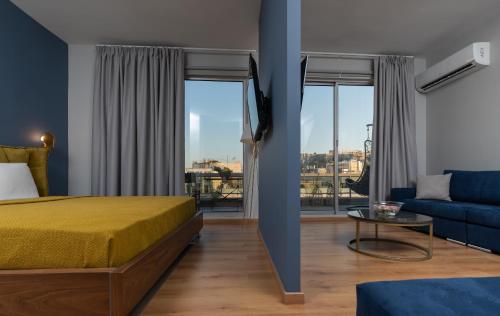 アテネにあるAthens City Center Apartmentのベッドとソファと窓があるホテルの部屋