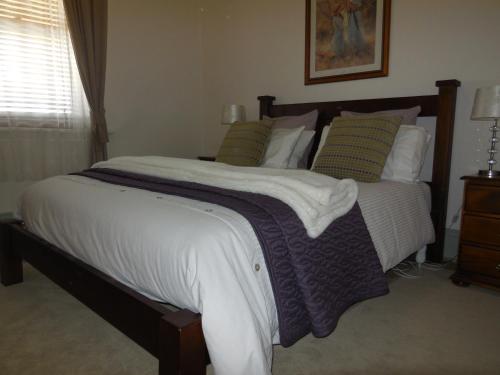 een slaapkamer met een groot bed met kussens bij Amalie Cottage Waikerie Unit 1 in Waikerie