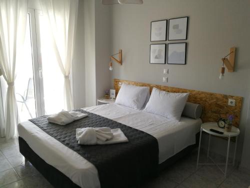 sypialnia z łóżkiem z dwoma ręcznikami w obiekcie PhiloxenInn w mieście Polijiros