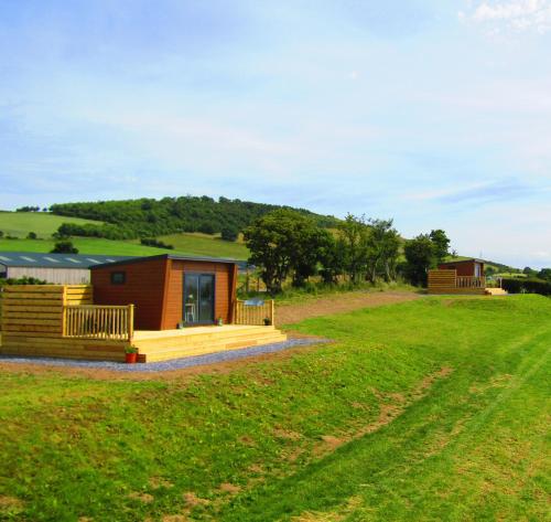 a cabin in the middle of a green field at Waenfechan Glamping with Hot Tubs in Colwyn Bay