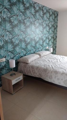 a bedroom with a bed with a blue and green wallpaper at apartamento la carrera in Mondaria