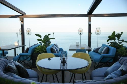 a patio with chairs and tables and a view of the ocean at Kolyada Hotel in Odesa