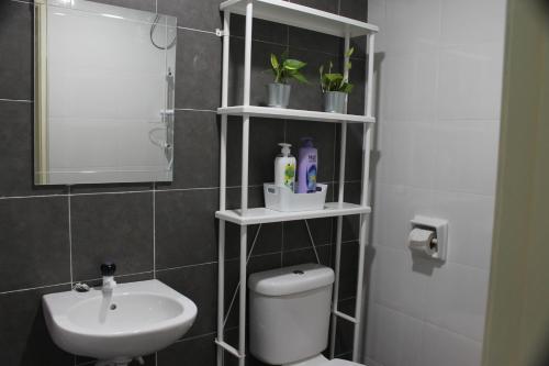 a bathroom with a toilet and a sink and a mirror at Luxury Kuala Selangor Homestay in Kuala Selangor