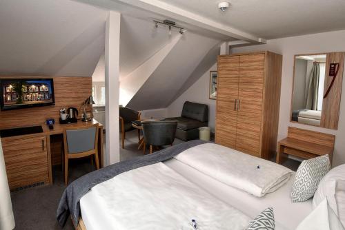 a bedroom with a bed and a desk and a chair at Hotel Stadt Hamburg in Heiligenhafen