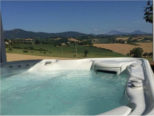 a bath tub filled with water with a view of a field at Serre Alte Landscape Luxury Rooms in Matelica