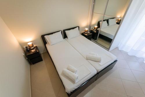 a large bed in a room with a mirror at Grand Suites with Private Pools in Kalamata