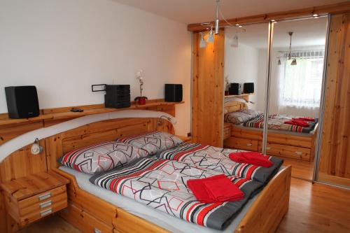 Un dormitorio con una gran cama de madera con almohadas rojas en Dům v Českém ráji en Dolní Bousov