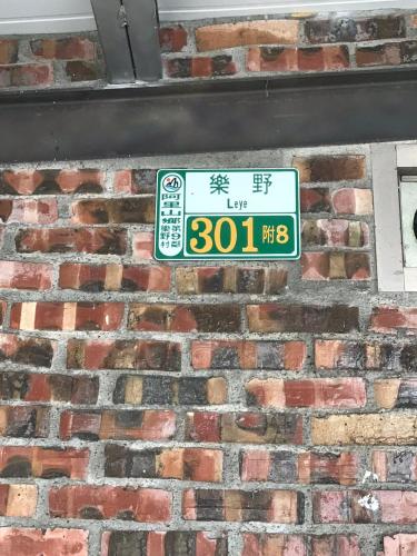 a sign on the side of a brick wall at SuWaNa in Leye