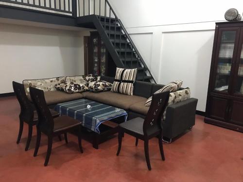 a living room with a couch and chairs and a staircase at SuWaNa in Leye