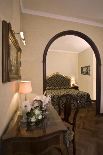 a room with a bed and a table with flowers at Hotel Vittoria in Pesaro